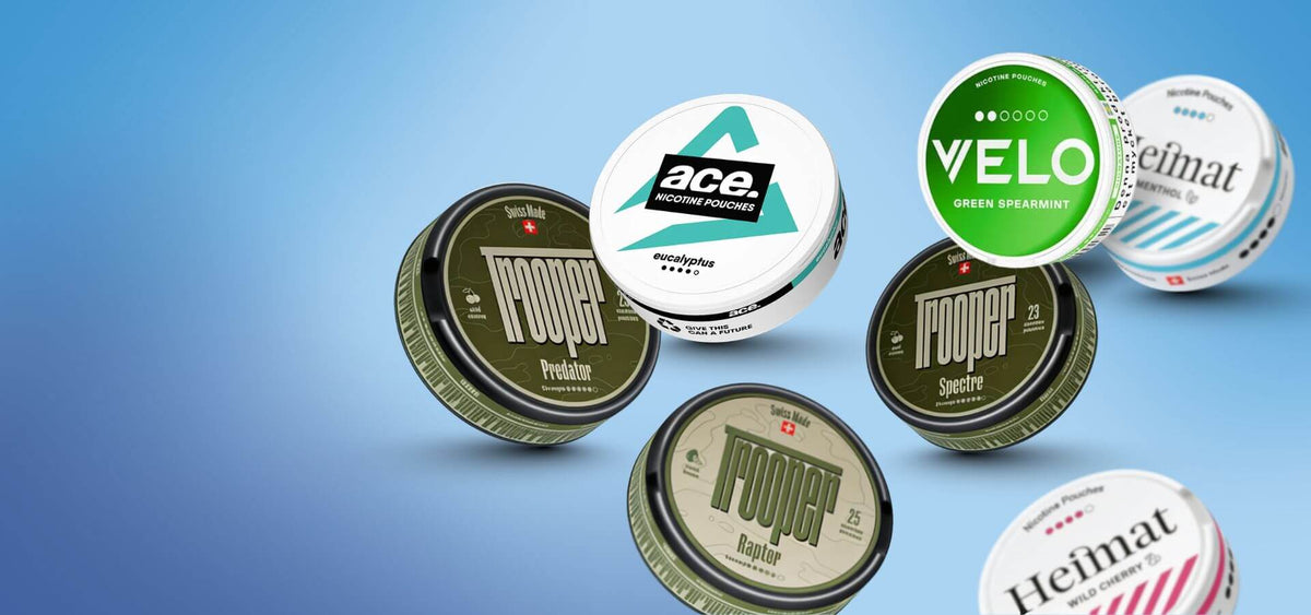 Snus and nicotine pouches selection: VELO Green Spearmint and Heimat cans on blue background